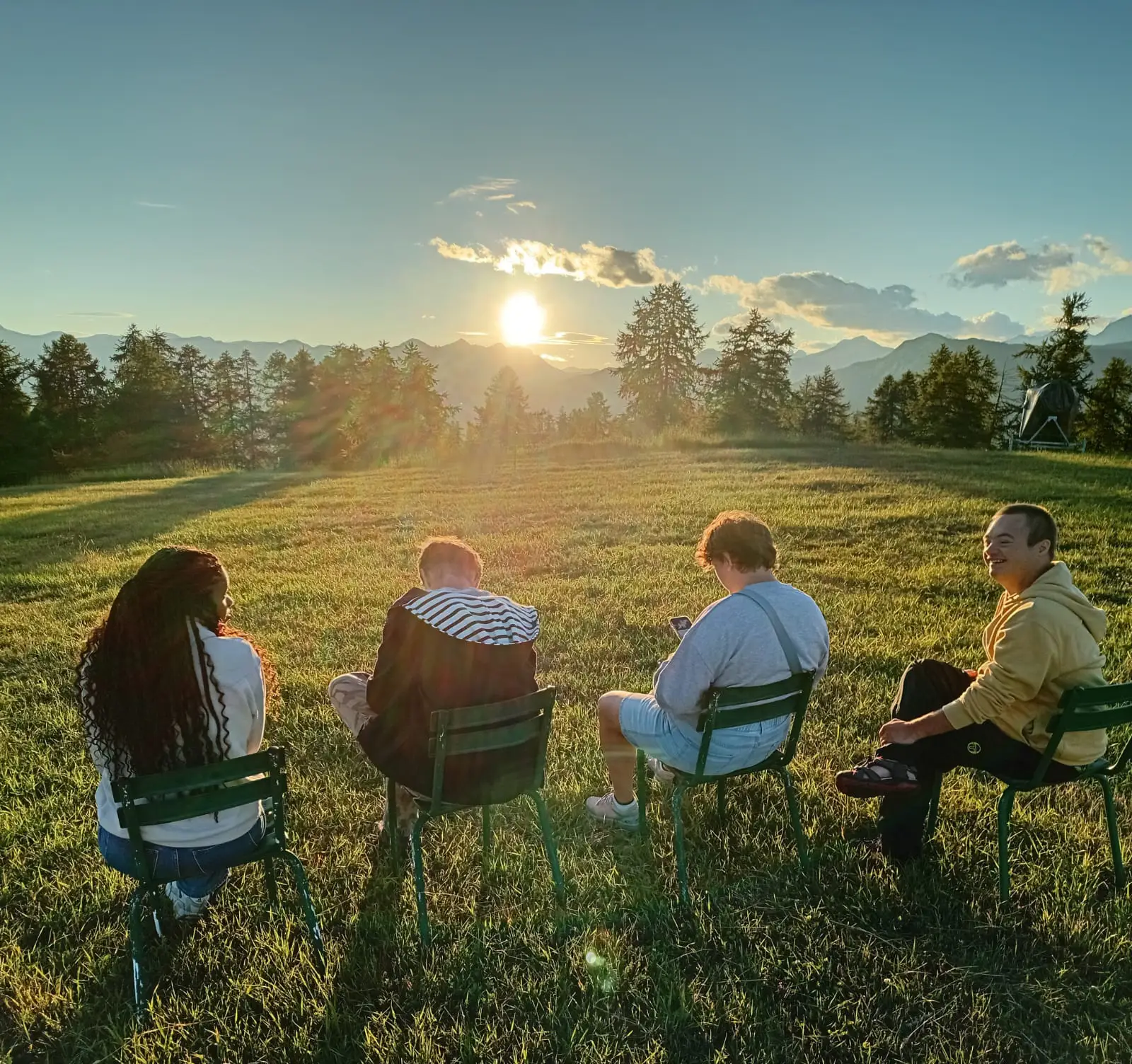 Groupe de jeunes réunis en extérieur au coucher du soleil