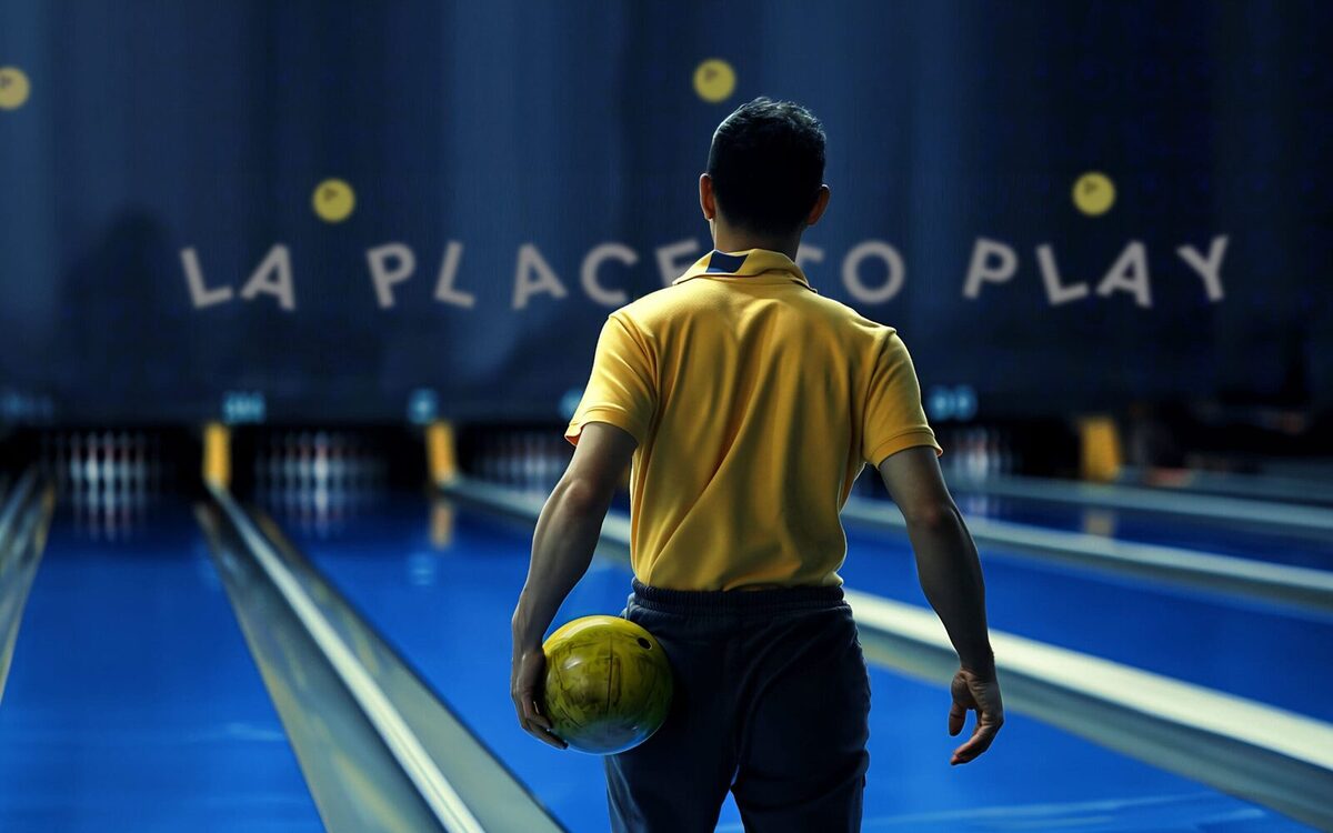 Joueur de bowling s'apprêtant à lancer sa boule sur la piste