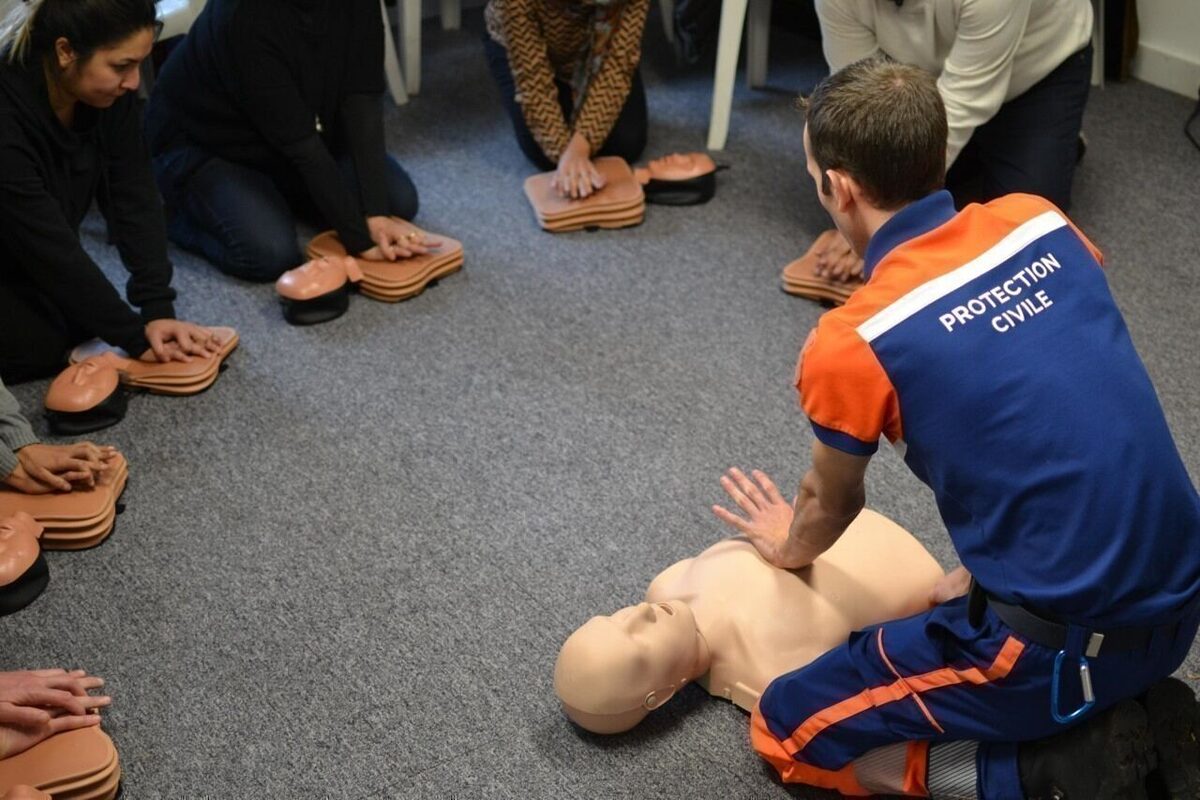 Formateur de la Protection Civile enseignant le massage cardiaque sur mannequin