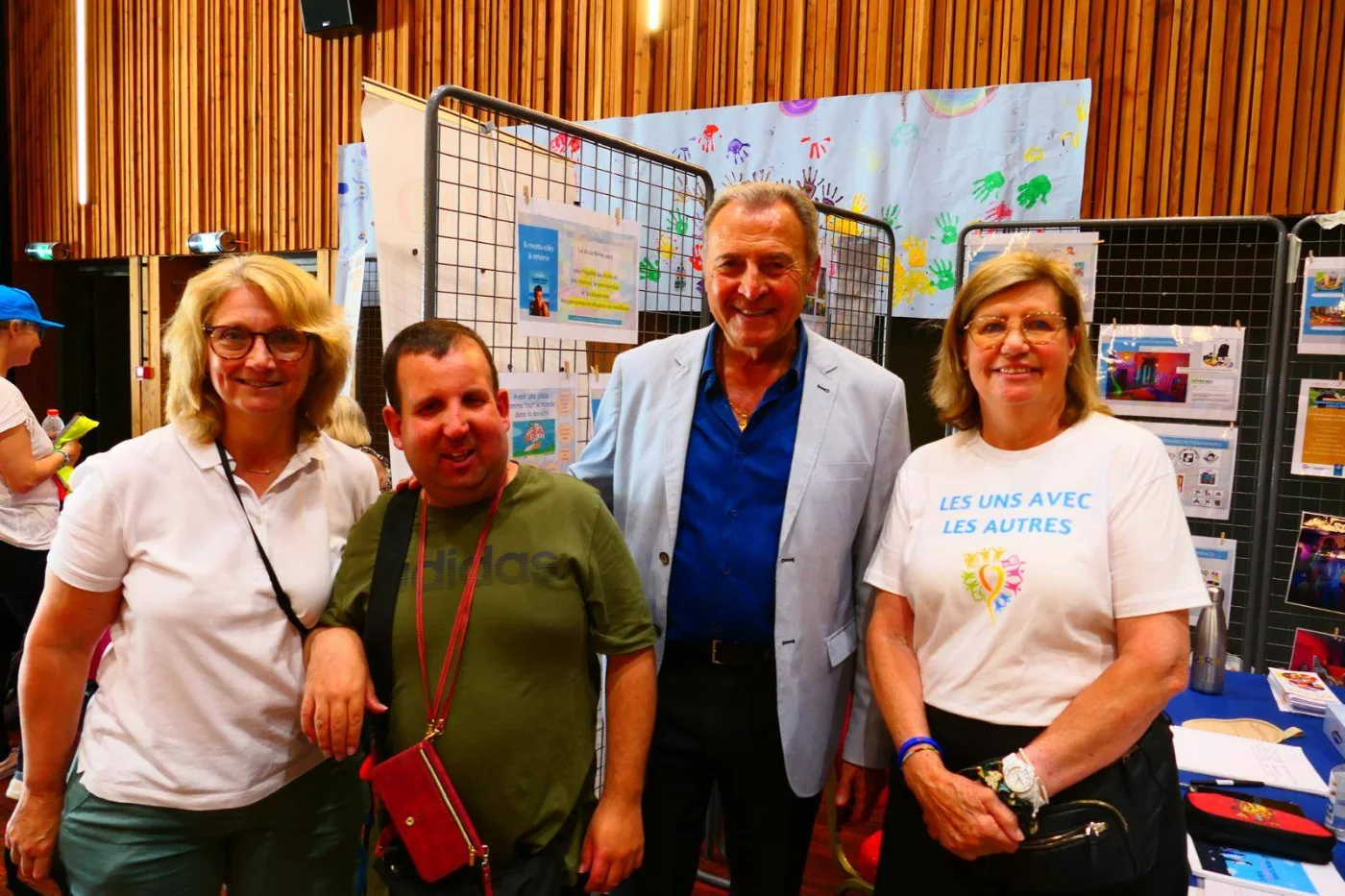 Visiteurs et bénévoles réunis devant le stand d'API-END